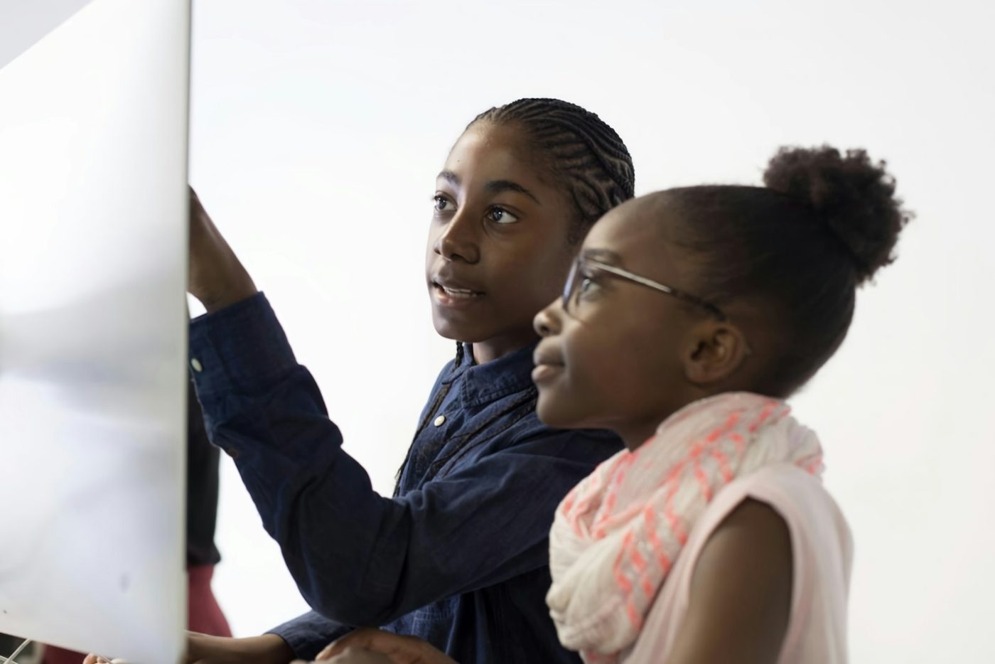 Two teenage girls working together at a computer