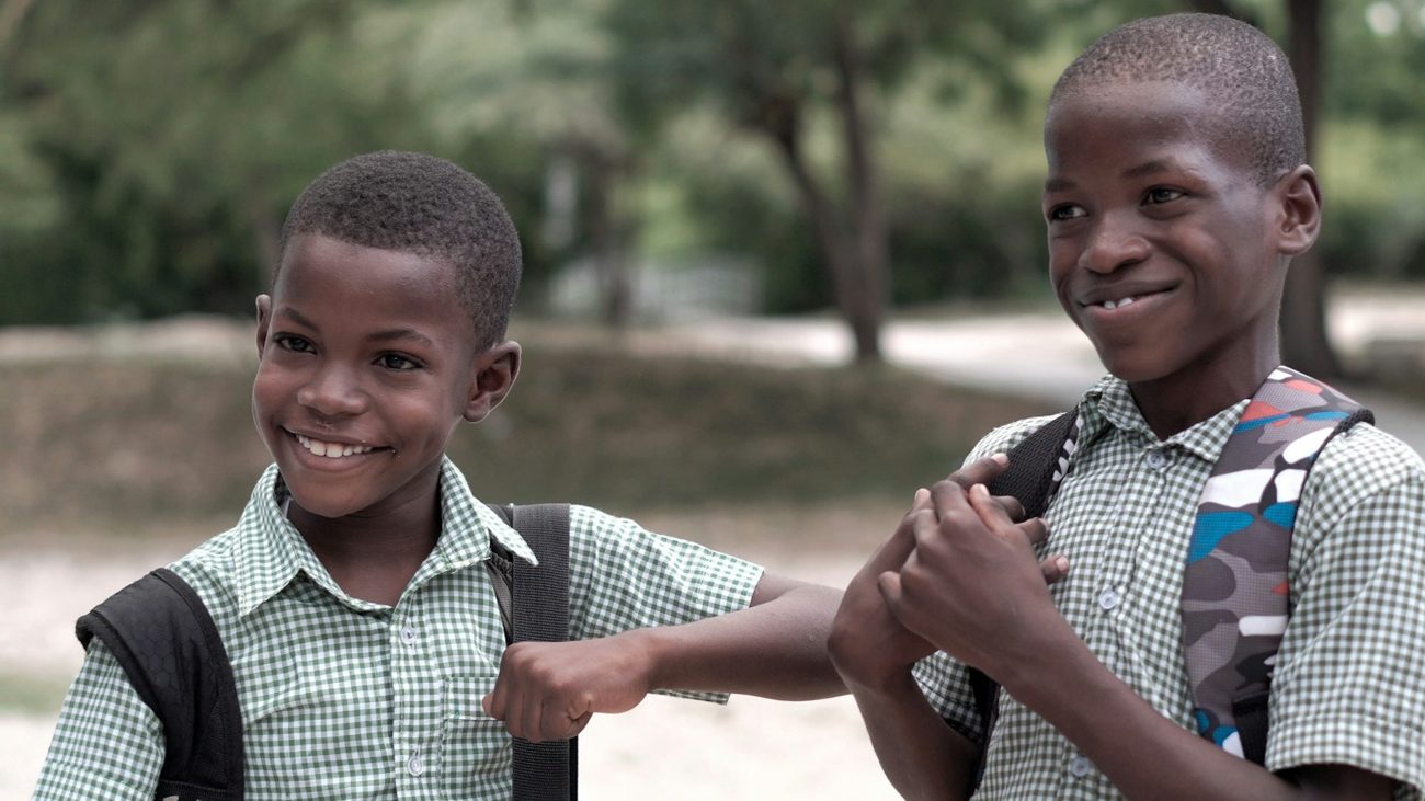Two smiling schoolboys with backpacks
